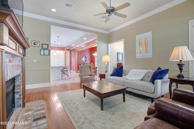 302 River Ranch Blvd, Lafayette, LA 70508 - living room featuring a ceiling fan, light wood-style floors, a brick fireplace, wainscoting, and recessed lighting