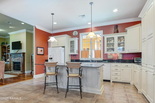 302 River Ranch Blvd, Lafayette, LA 70508 - kitchen featuring white appliances, a center island, glass insert cabinets, white cabinets, and a kitchen bar