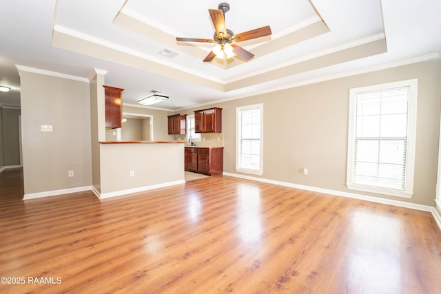 1518 S Patout St, New Iberia, LA 70560 - unfurnished living room featuring a raised ceiling, ornamental molding, a ceiling fan, and light wood-style floors