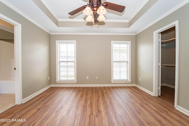 1518 S Patout St, New Iberia, LA 70560 - unfurnished bedroom with a spacious closet, a raised ceiling, wood finished floors, and crown molding