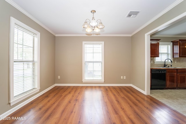 1518 S Patout St, New Iberia, LA 70560 - unfurnished dining area featuring a chandelier, light wood-style flooring, and crown molding