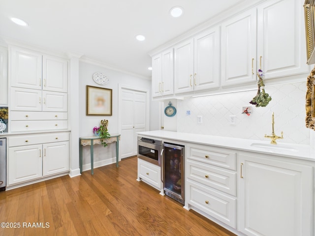 109 Canterbury Rd, Lafayette, LA 70503 - kitchen with light countertops, backsplash, white cabinetry, wine cooler, and ornamental molding