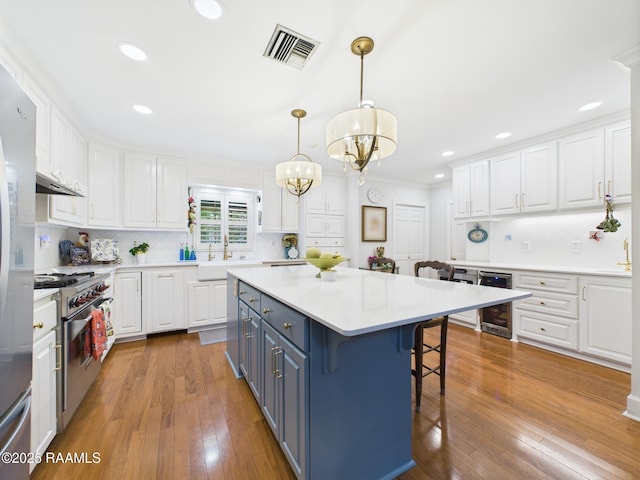 109 Canterbury Rd, Lafayette, LA 70503 - kitchen featuring white cabinetry, a breakfast bar area, decorative backsplash, a chandelier, and recessed lighting