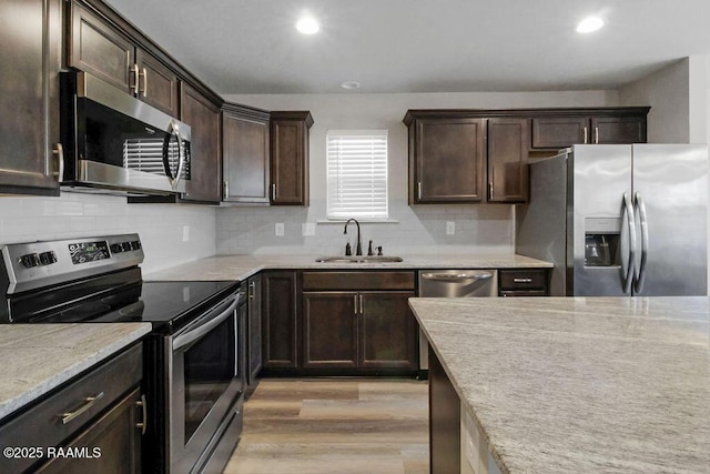 115 Sandstone Ave, Scott, LA 70583 - kitchen featuring stainless steel appliances, light wood-style flooring, dark brown cabinetry, recessed lighting, and backsplash