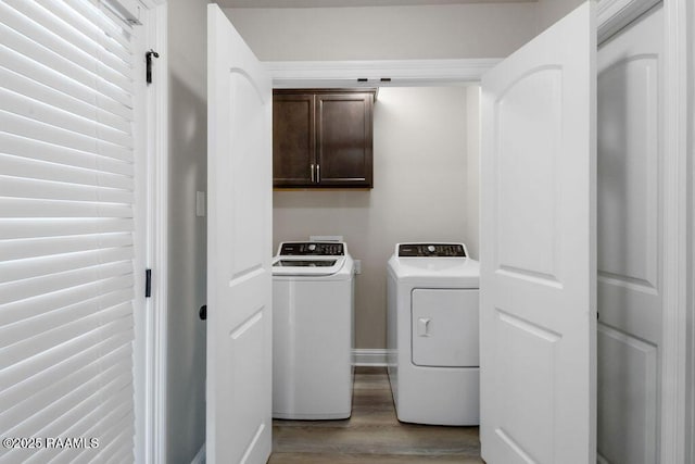 115 Sandstone Ave, Scott, LA 70583 - laundry area featuring cabinet space, wood finished floors, and washing machine and clothes dryer