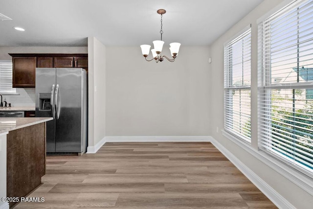 115 Sandstone Ave, Scott, LA 70583 - kitchen with stainless steel fridge with ice dispenser, dark brown cabinets, a chandelier, decorative light fixtures, and light wood finished floors