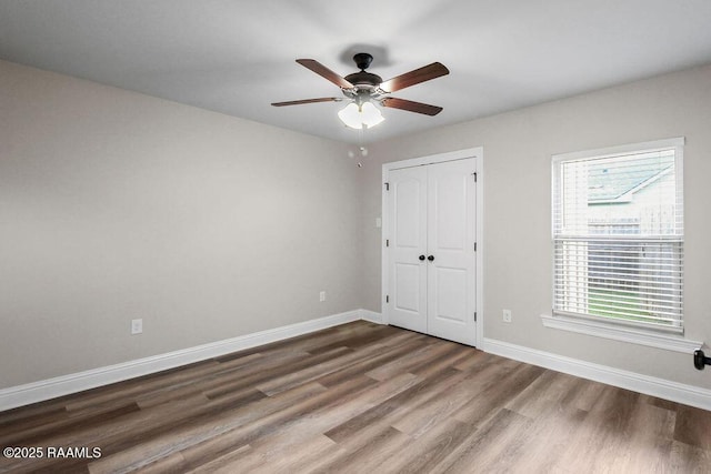 115 Sandstone Ave, Scott, LA 70583 - unfurnished bedroom with multiple windows, wood finished floors, a closet, and ceiling fan