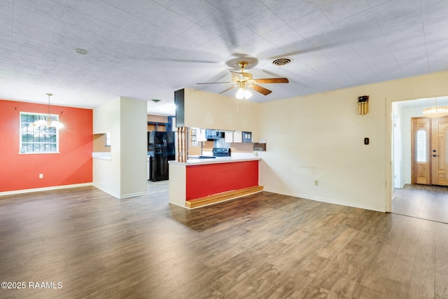 208 W Church St, Opelousas, LA 70570 - kitchen featuring black fridge, a chandelier, a peninsula, range with electric cooktop, and dark wood-type flooring