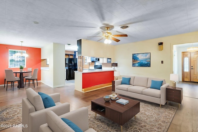 208 W Church St, Opelousas, LA 70570 - living room featuring a chandelier, wood finished floors, and ceiling fan