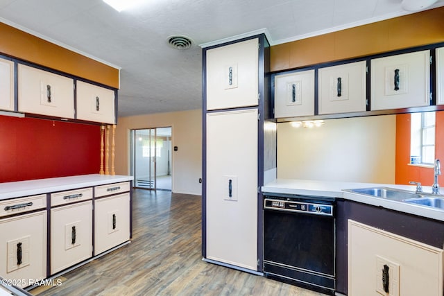 208 W Church St, Opelousas, LA 70570 - kitchen with dishwasher, light countertops, light wood-type flooring, and white cabinets