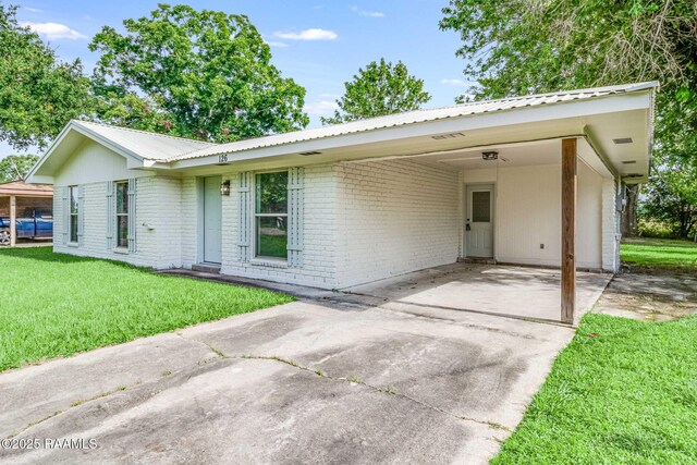 126 Lindsey Cir, Carencro, LA 70520 - ranch-style house featuring brick siding, a front yard, concrete driveway, a metal roof, and a carport