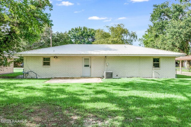 126 Lindsey Cir, Carencro, LA 70520 - back of property featuring a yard, a patio area, a metal roof, and brick siding