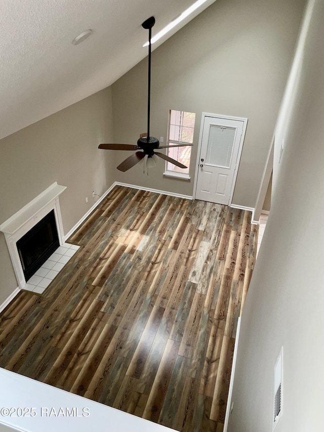 113 Earline Dr, Lafayette, LA 70506 - unfurnished living room with wood finished floors, ceiling fan, a tile fireplace, and high vaulted ceiling