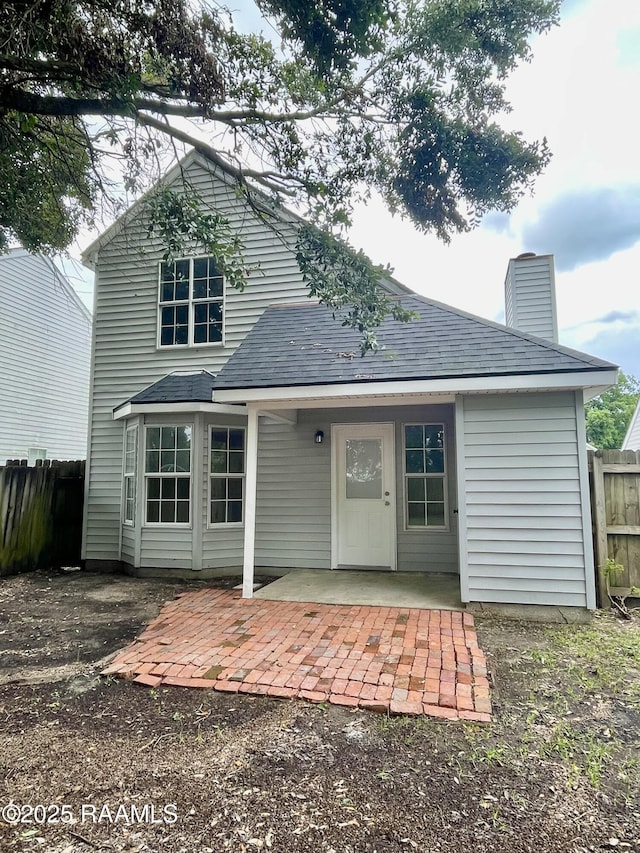 113 Earline Dr, Lafayette, LA 70506 - back of property with a shingled roof, a chimney, and a patio