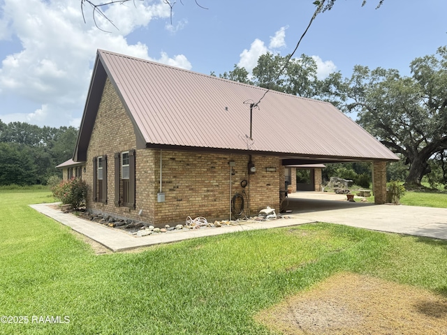 6516 Daspit Rd, New Iberia, LA 70563 - view of home's exterior featuring an attached carport, a lawn, brick siding, concrete driveway, and a metal roof