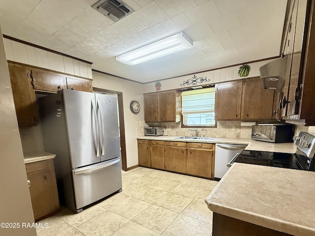 6516 Daspit Rd, New Iberia, LA 70563 - kitchen featuring appliances with stainless steel finishes, light countertops, decorative backsplash, light tile patterned floors, and ornamental molding