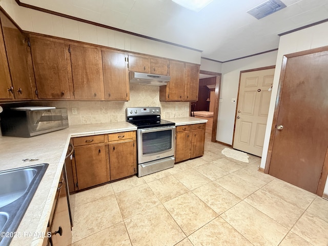 6516 Daspit Rd, New Iberia, LA 70563 - kitchen with stainless steel electric range oven, under cabinet range hood, decorative backsplash, brown cabinets, and light countertops