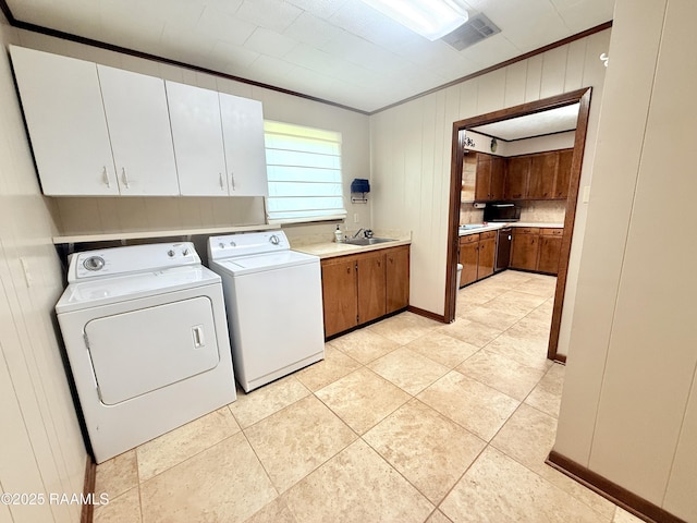 6516 Daspit Rd, New Iberia, LA 70563 - washroom featuring cabinet space, washer and clothes dryer, ornamental molding, light tile patterned floors, and wooden walls