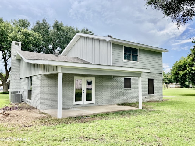 311 Fernway Ln, Duson, LA 70529 - rear view of house with brick siding, a yard, a patio area, a chimney, and board and batten siding