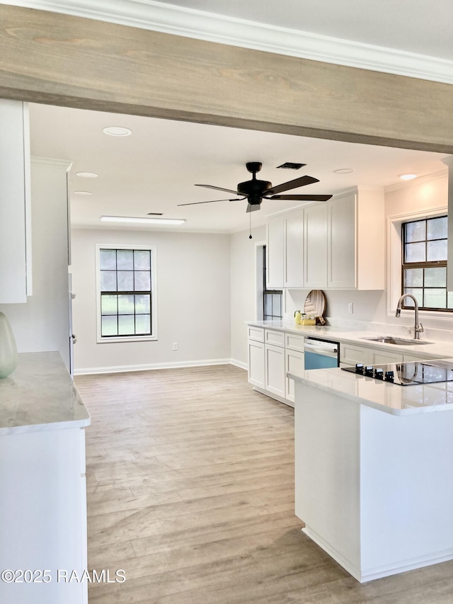 311 Fernway Ln, Duson, LA 70529 - kitchen with ceiling fan, white cabinets, light countertops, crown molding, and light wood-style floors