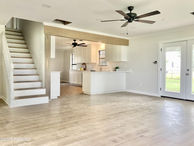 311 Fernway Ln, Duson, LA 70529 - unfurnished living room with crown molding, light wood finished floors, stairs, french doors, and ceiling fan