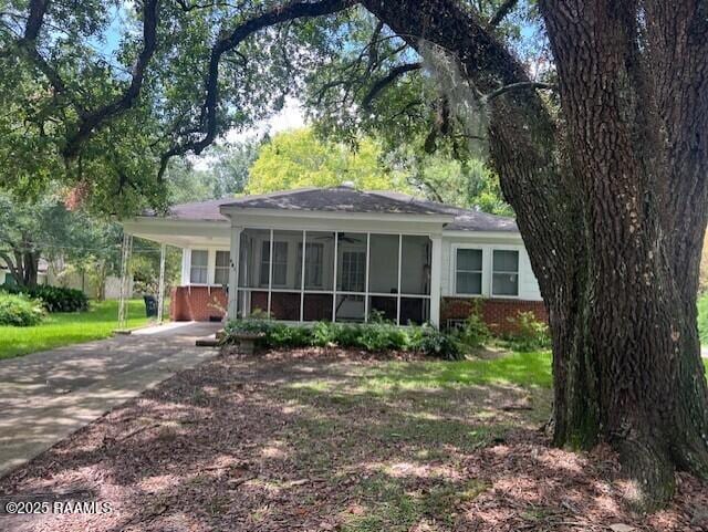 526 E Main St, New Iberia, LA 70560 - view of front facade with a sunroom, driveway, and brick siding