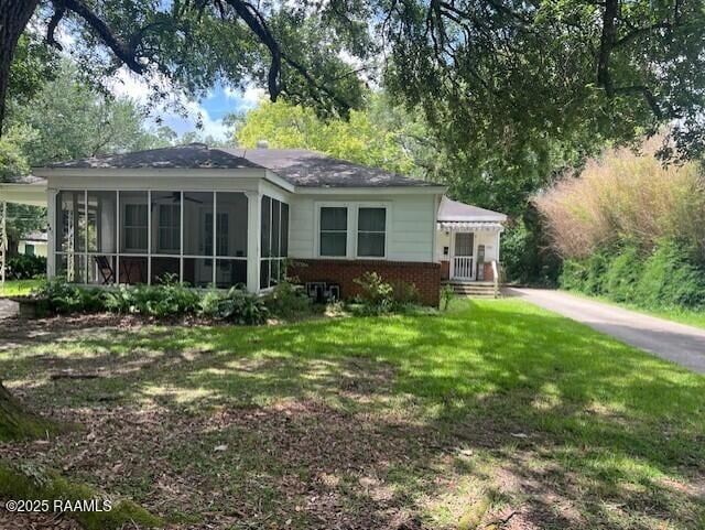 526 E Main St, New Iberia, LA 70560 - back of house with a sunroom, a lawn, and brick siding