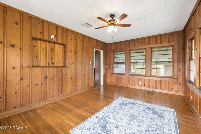 124 Taylor St, New Iberia, LA 70560 - unfurnished room with wood finished floors, wood walls, and ceiling fan