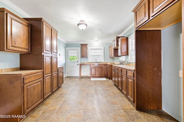 124 Taylor St, New Iberia, LA 70560 - kitchen with ornamental molding, brown cabinetry, and light countertops