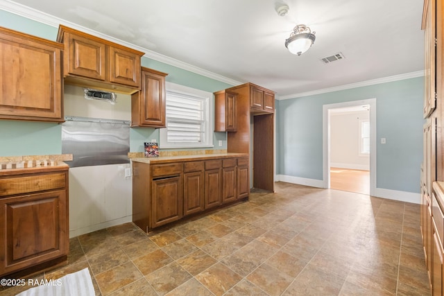 124 Taylor St, New Iberia, LA 70560 - kitchen with brown cabinetry, ornamental molding, light countertops, and stone finish floors