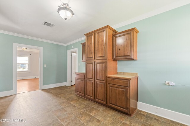 124 Taylor St, New Iberia, LA 70560 - kitchen with ornamental molding, light countertops, and brown cabinetry
