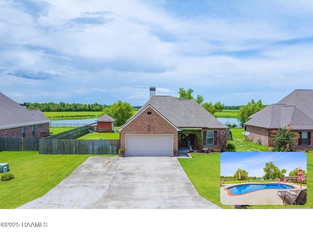 1181 Grand Loop, Breaux Bridge, LA 70517 - view of front of property with brick siding, driveway, an attached garage, a chimney, and a water view