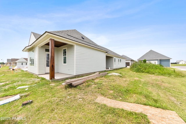 202 Keystone Dr, Scott, LA 70583 - view of property exterior featuring a patio area, a yard, and roof with shingles