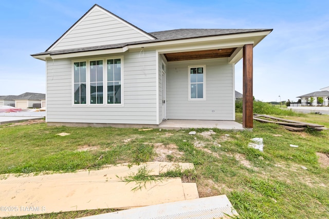202 Keystone Dr, Scott, LA 70583 - rear view of house featuring a patio, a lawn, and roof with shingles