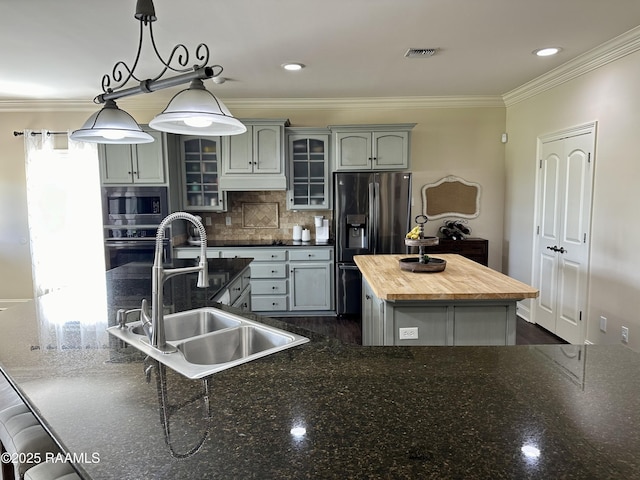 7421 W Congress St, Duson, LA 70529 - kitchen featuring a center island with sink, butcher block counters, appliances with stainless steel finishes, crown molding, and backsplash