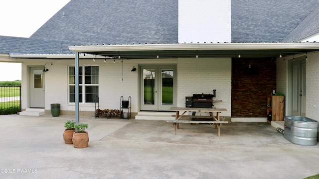 7421 W Congress St, Duson, LA 70529 - rear view of house featuring french doors, roof with shingles, brick siding, and a patio area