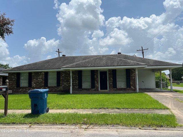 217 Marie St, Scott, LA 70583 - single story home with a shingled roof, an attached carport, driveway, a front yard, and brick siding