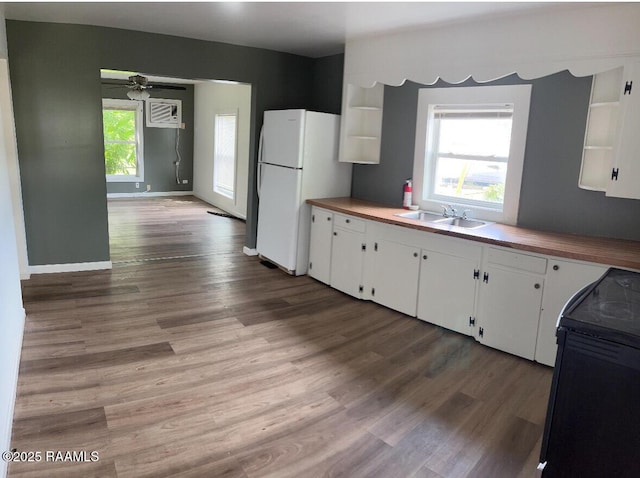 1136 Tupelo St, New Iberia, LA 70560 - kitchen featuring freestanding refrigerator, range, white cabinetry, wood finished floors, and open shelves