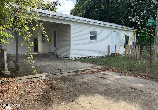 1136 Tupelo St, New Iberia, LA 70560 - back of property with entry steps, a carport, and a metal roof