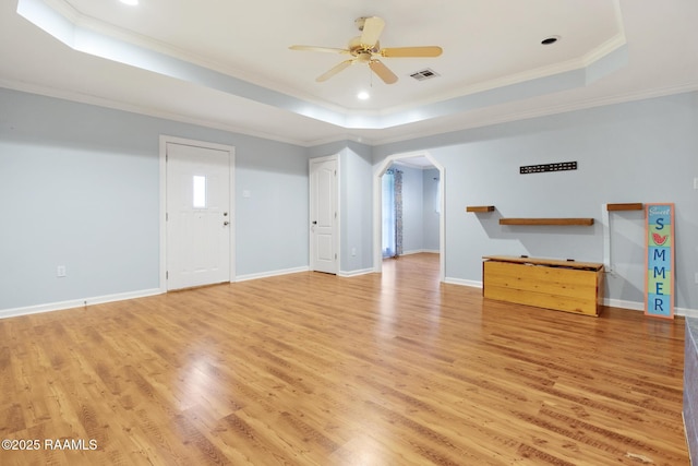 1034 Hollow Oaks Rd, Breaux Bridge, LA 70517 - unfurnished living room with a tray ceiling, ceiling fan, arched walkways, light wood finished floors, and ornamental molding