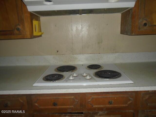 1248 N Portage Rd, Arnaudville, LA 70512 - kitchen with light countertops, white electric cooktop, brown cabinetry, and extractor fan
