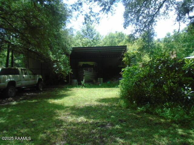 1248 N Portage Rd, Arnaudville, LA 70512 - view of grassy yard with a carport
