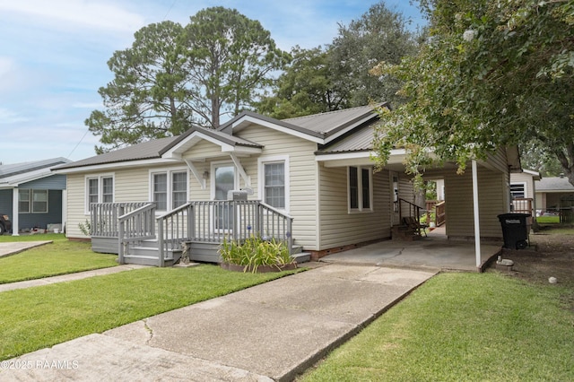 411 Donald St, New Iberia, LA 70563 - view of front of property featuring a carport, driveway, a front yard, and a metal roof