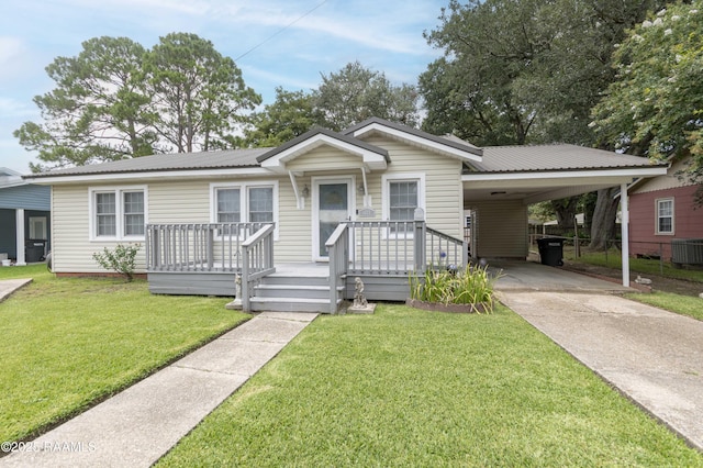 411 Donald St, New Iberia, LA 70563 - view of front of property featuring concrete driveway, a carport, a front lawn, and a metal roof