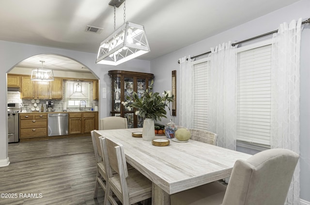 411 Donald St, New Iberia, LA 70563 - dining room with arched walkways, dark wood-type flooring, and a chandelier