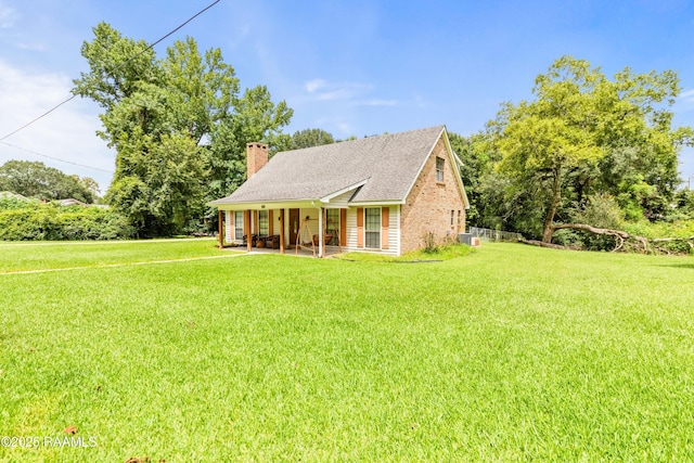3317 Walnut Dr, Opelousas, LA 70570 - cape cod-style house featuring a front lawn, a chimney, covered porch, and a shingled roof