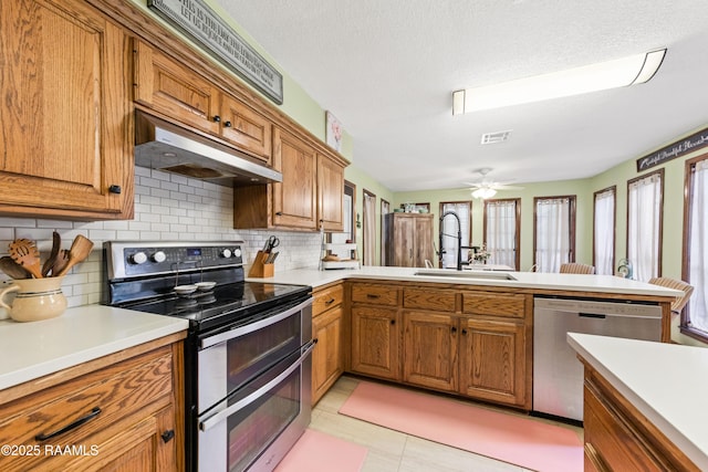 3317 Walnut Dr, Opelousas, LA 70570 - kitchen with stainless steel appliances, brown cabinets, light countertops, and tasteful backsplash