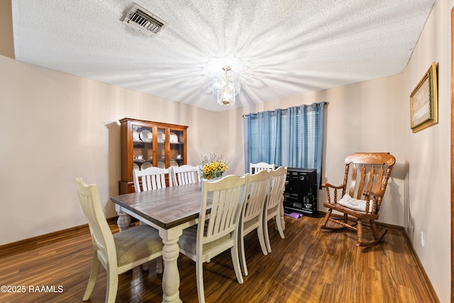 3317 Walnut Dr, Opelousas, LA 70570 - dining space with dark wood-style floors, a chandelier, and a textured ceiling
