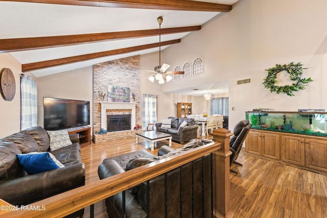 3317 Walnut Dr, Opelousas, LA 70570 - living area featuring wood finished floors, beamed ceiling, ceiling fan, a brick fireplace, and high vaulted ceiling