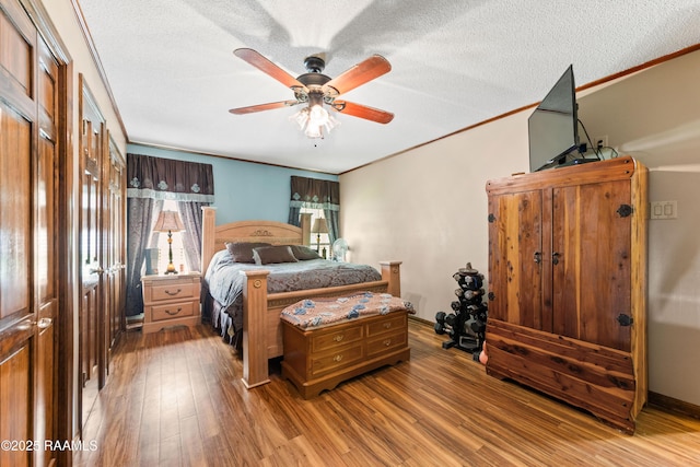 3317 Walnut Dr, Opelousas, LA 70570 - bedroom featuring light wood-style flooring, a textured ceiling, a ceiling fan, and crown molding